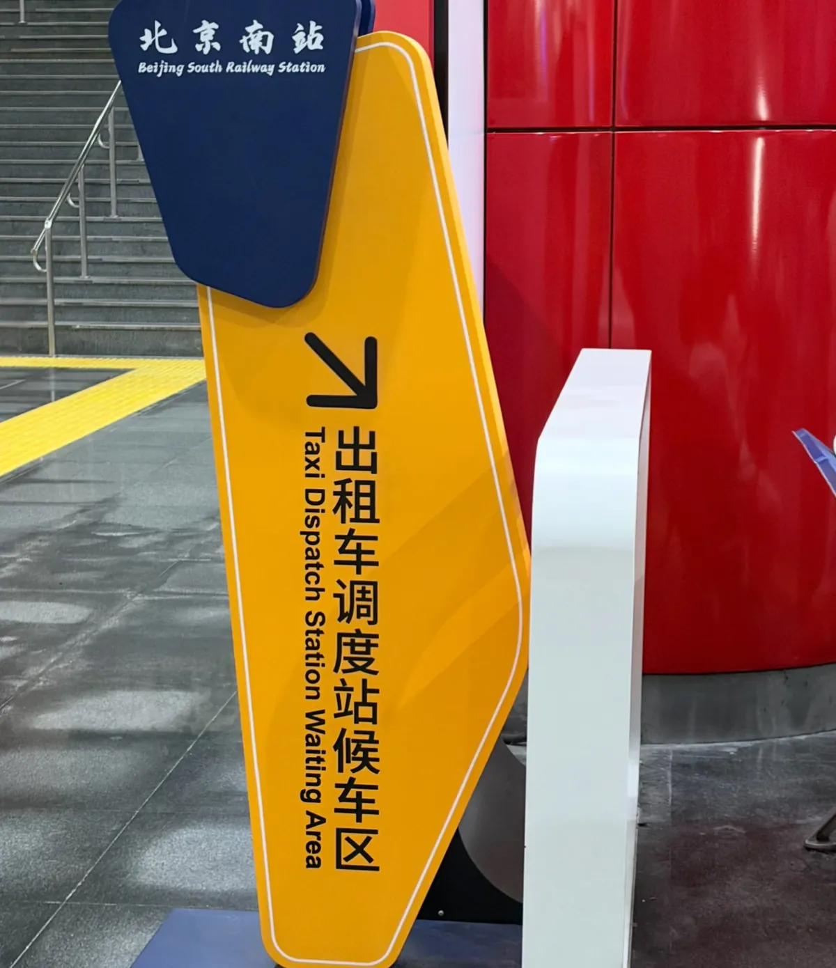 Yellow sign for the taxi dispatch waiting area inside Beijing South Railway Station