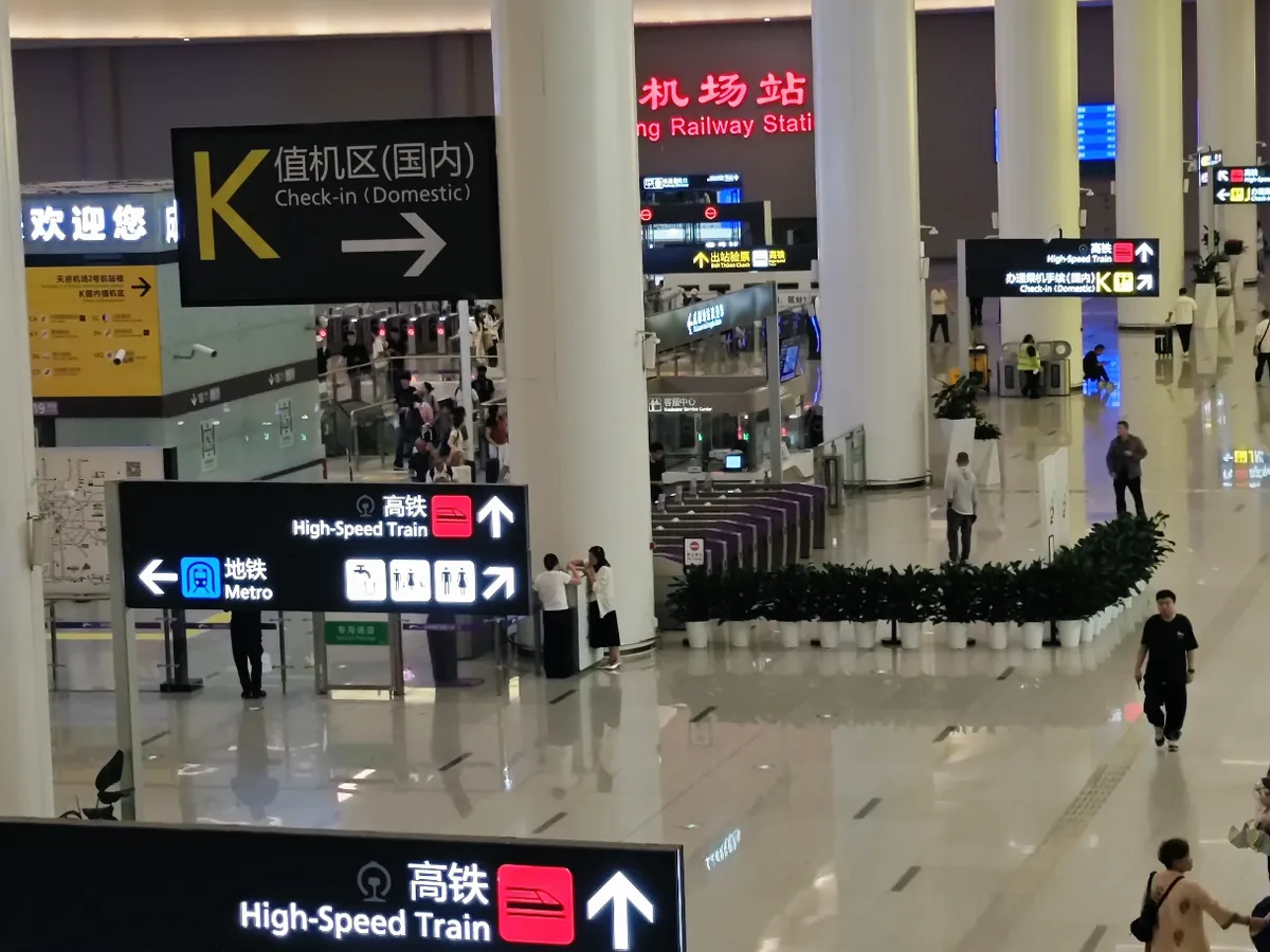 The transport hall at Chengdu Tianfu Airport with signs for the high-speed train, the metro and check-in