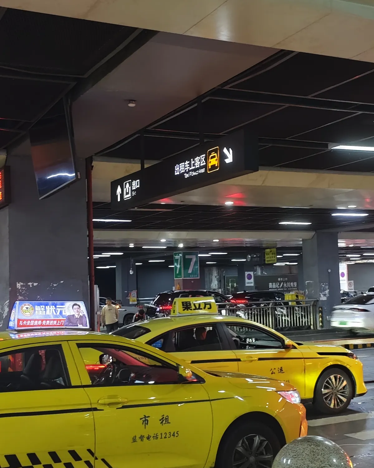 Taxis waiting under the overhead taxi pick-up sign at Chongqing North Railway Station