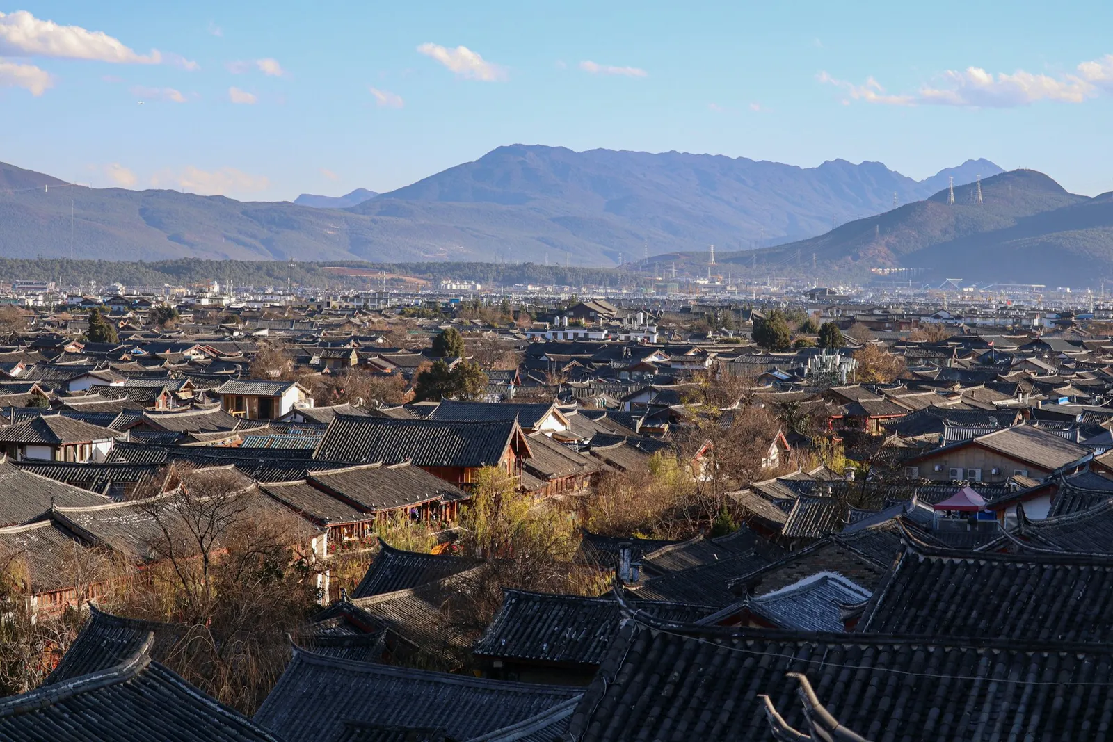 Lijiang old-town rooftops with mountains beyond