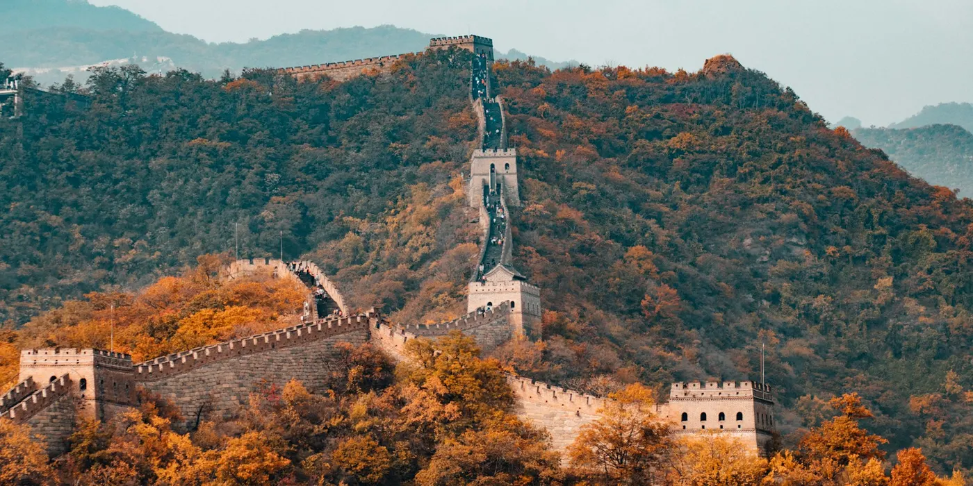 The Great Wall winding across hills covered in autumn foliage