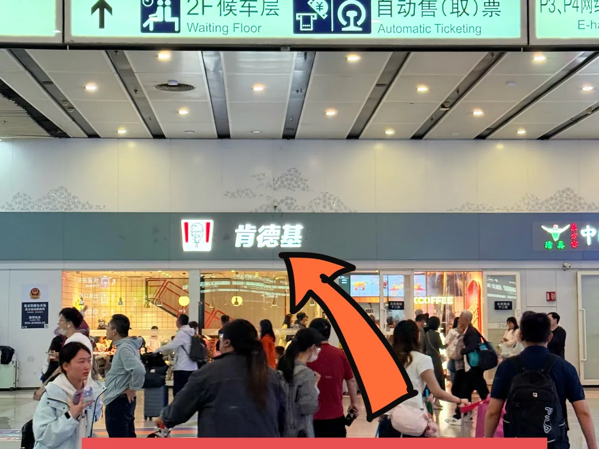 A crowded Beijing railway station concourse with signs for the North Exit, taxis and ticket machines, as it looks around public holidays