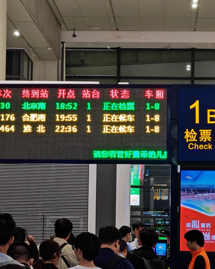 A ticket gate display at Shanghai Hongqiao showing which train is boarding, its destination, platform and carriage range
